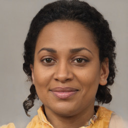 Joyful black adult female with medium  brown hair and brown eyes