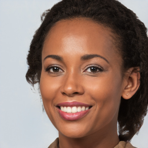 Joyful black young-adult female with medium  brown hair and brown eyes