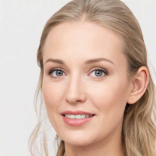 Joyful white young-adult female with long  brown hair and blue eyes