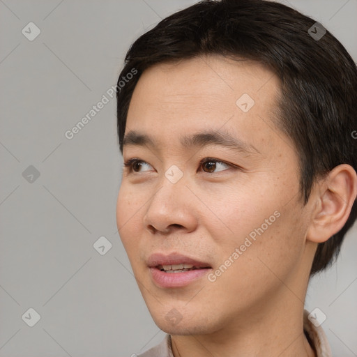 Joyful asian young-adult male with short  brown hair and brown eyes