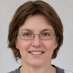 Joyful white young-adult female with medium  brown hair and blue eyes