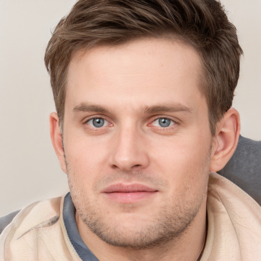 Joyful white young-adult male with short  brown hair and grey eyes