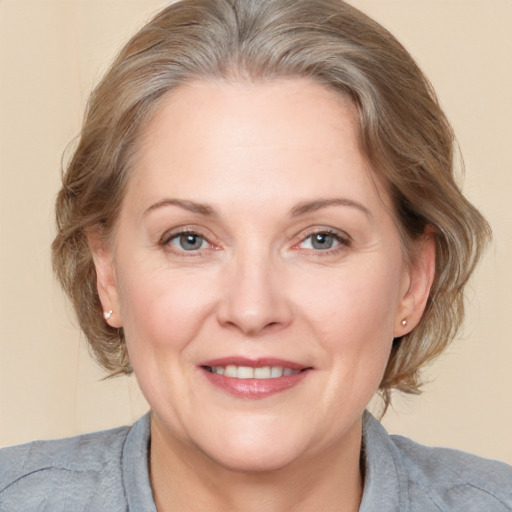 Joyful white adult female with medium  brown hair and grey eyes