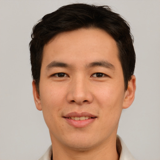 Joyful asian young-adult male with short  brown hair and brown eyes