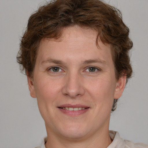 Joyful white young-adult male with short  brown hair and blue eyes