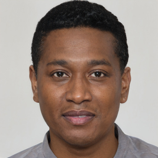 Joyful black young-adult male with short  black hair and brown eyes