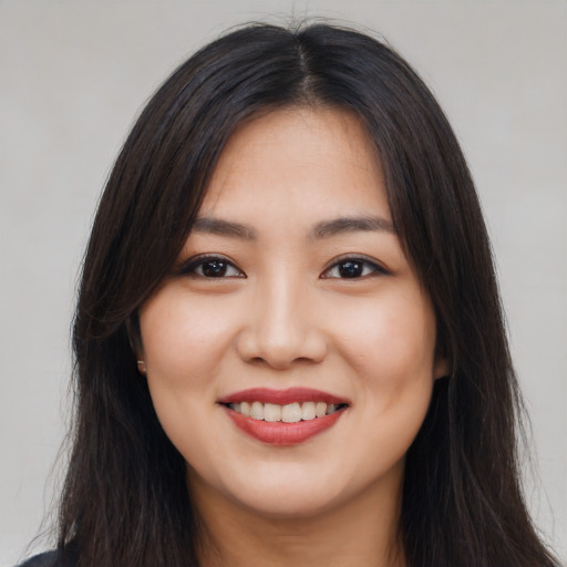 Joyful asian young-adult female with long  brown hair and brown eyes