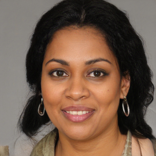 Joyful black young-adult female with long  brown hair and brown eyes