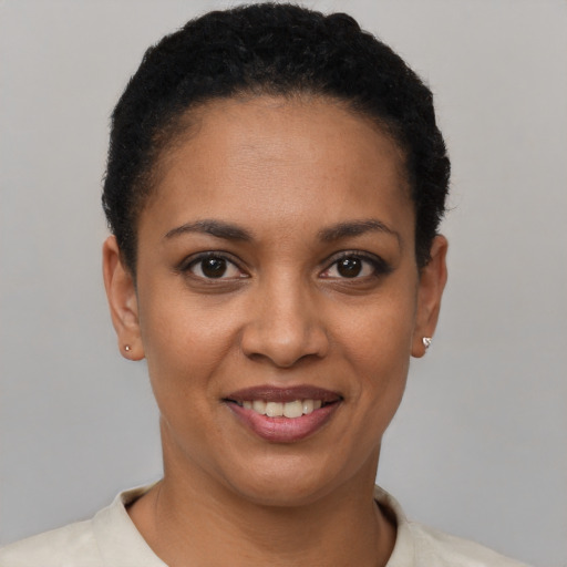 Joyful black young-adult female with short  black hair and brown eyes