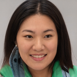 Joyful asian young-adult female with long  brown hair and brown eyes