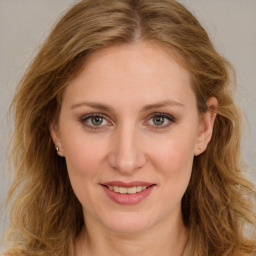 Joyful white young-adult female with long  brown hair and green eyes