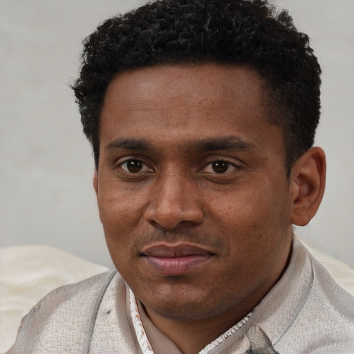 Joyful black young-adult male with short  brown hair and brown eyes