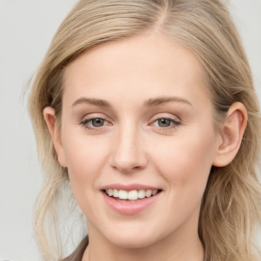 Joyful white young-adult female with long  brown hair and blue eyes