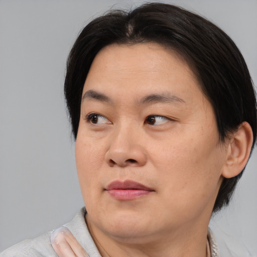 Joyful asian adult male with short  brown hair and brown eyes