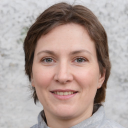 Joyful white adult female with medium  brown hair and grey eyes