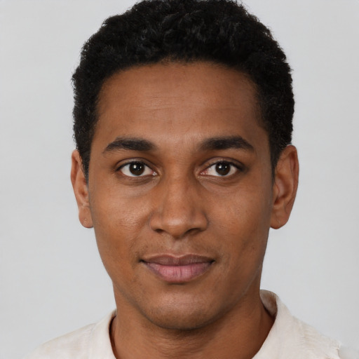 Joyful black young-adult male with short  black hair and brown eyes