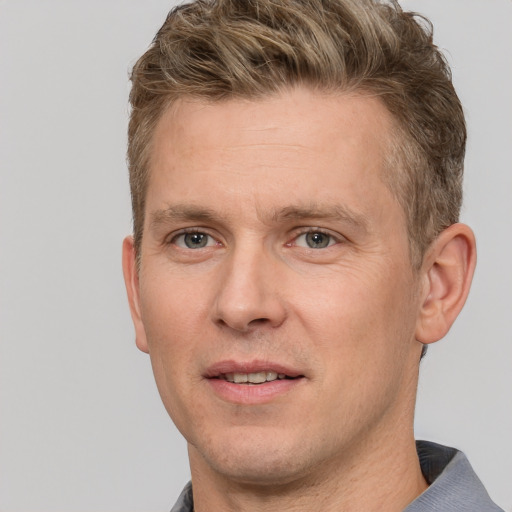 Joyful white adult male with short  brown hair and grey eyes