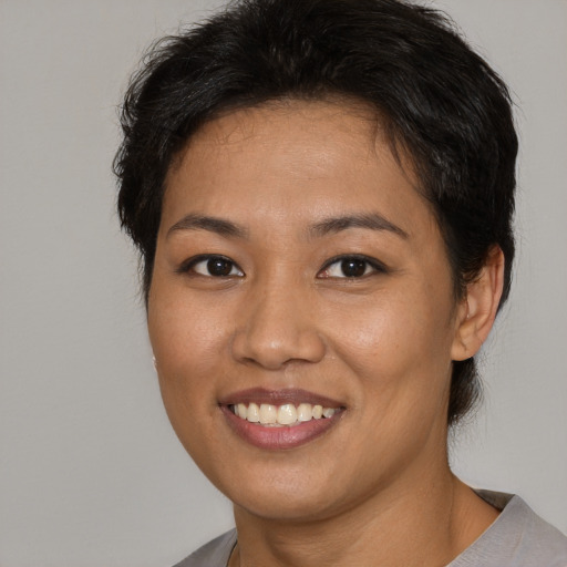 Joyful asian young-adult female with short  brown hair and brown eyes