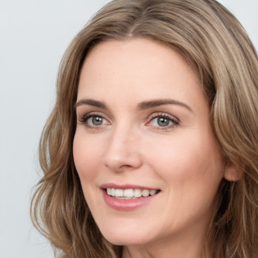 Joyful white young-adult female with long  brown hair and green eyes