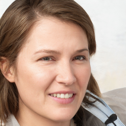 Joyful white young-adult female with medium  brown hair and blue eyes