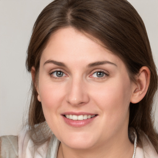 Joyful white young-adult female with medium  brown hair and grey eyes