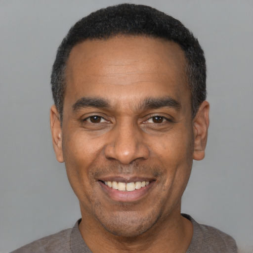 Joyful latino adult male with short  black hair and brown eyes