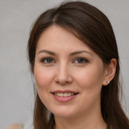 Joyful white young-adult female with long  brown hair and grey eyes