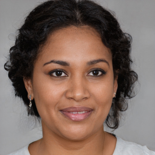 Joyful black adult female with medium  brown hair and brown eyes