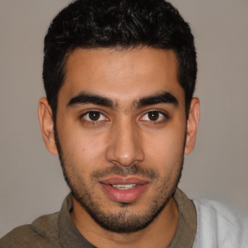 Joyful latino young-adult male with short  brown hair and brown eyes