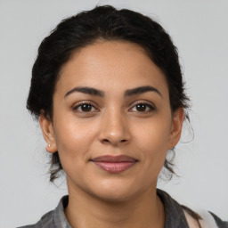 Joyful latino young-adult female with medium  brown hair and brown eyes