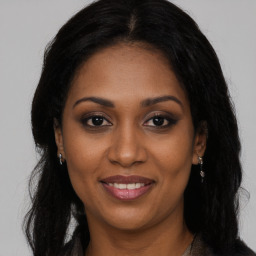 Joyful black young-adult female with long  black hair and brown eyes