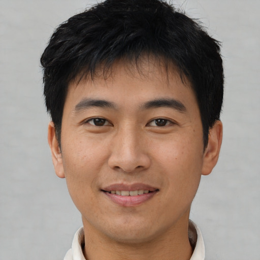 Joyful asian young-adult male with short  brown hair and brown eyes