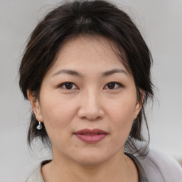 Joyful asian adult female with medium  brown hair and brown eyes