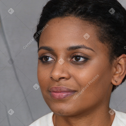 Joyful black young-adult female with short  brown hair and brown eyes