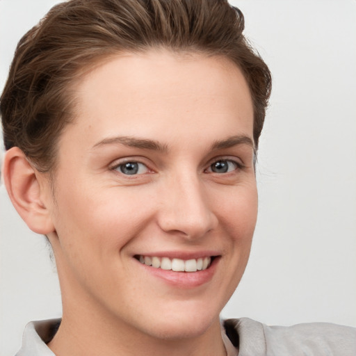 Joyful white young-adult female with short  brown hair and grey eyes