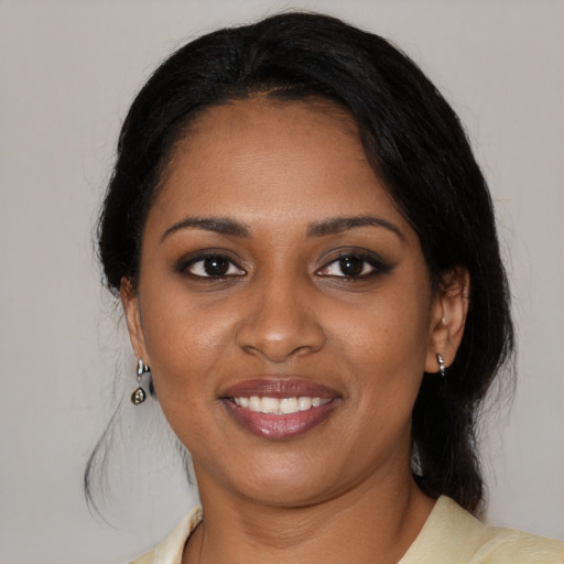 Joyful black young-adult female with medium  black hair and brown eyes