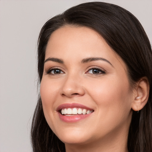 Joyful white young-adult female with long  brown hair and brown eyes