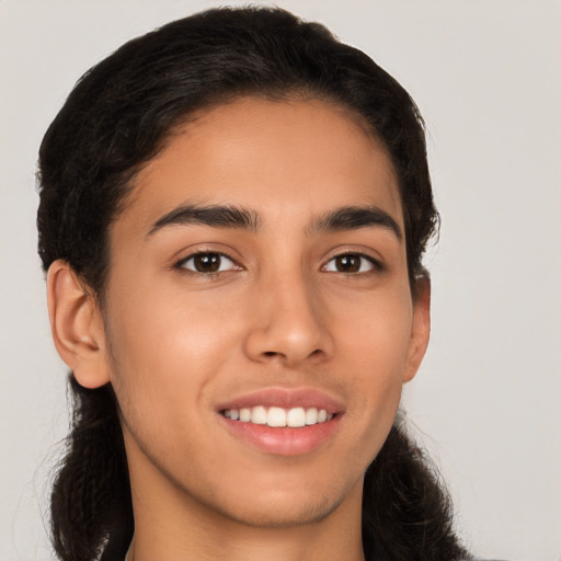 Joyful latino young-adult male with long  brown hair and brown eyes