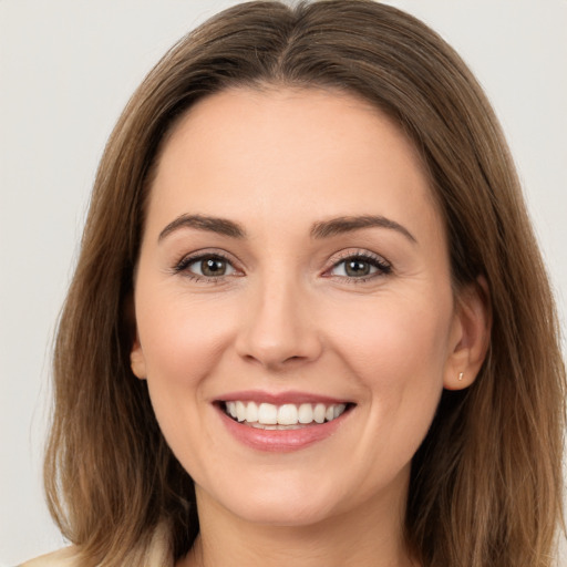 Joyful white young-adult female with long  brown hair and brown eyes