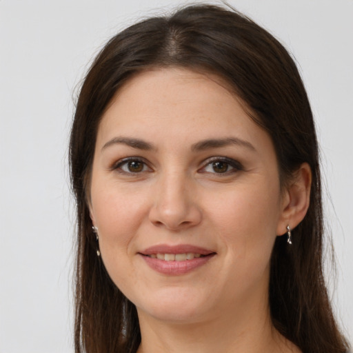 Joyful white young-adult female with long  brown hair and brown eyes