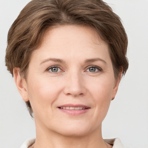 Joyful white adult female with short  brown hair and grey eyes