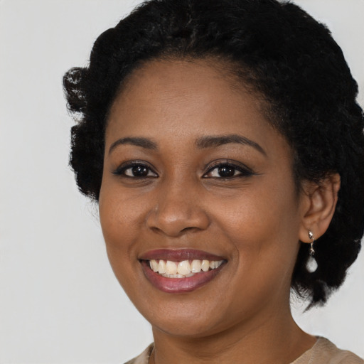Joyful black young-adult female with short  black hair and brown eyes