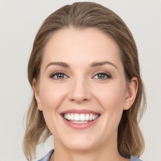 Joyful white young-adult female with medium  brown hair and grey eyes