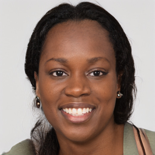 Joyful black young-adult female with long  black hair and brown eyes