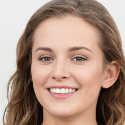 Joyful white young-adult female with long  brown hair and blue eyes