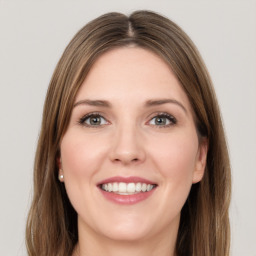 Joyful white young-adult female with long  brown hair and green eyes