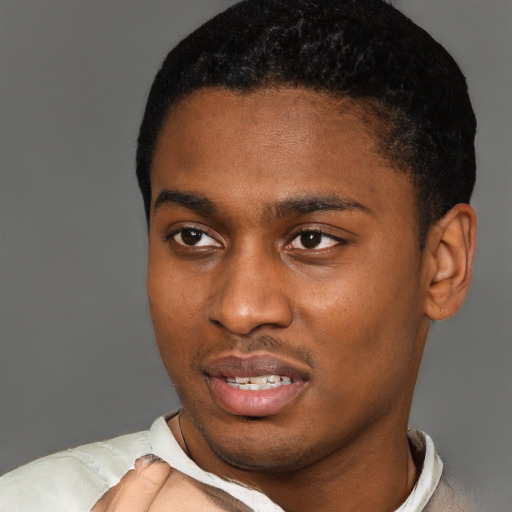 Joyful black young-adult male with short  black hair and brown eyes