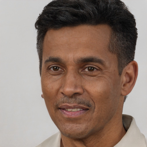 Joyful latino adult male with short  black hair and brown eyes
