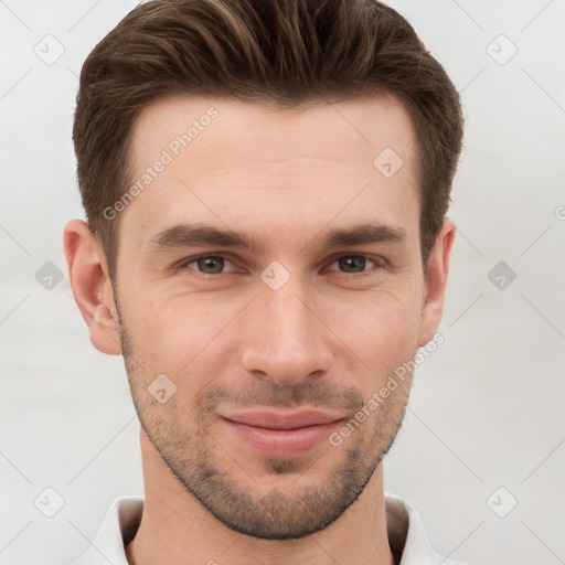 Joyful white young-adult male with short  brown hair and grey eyes