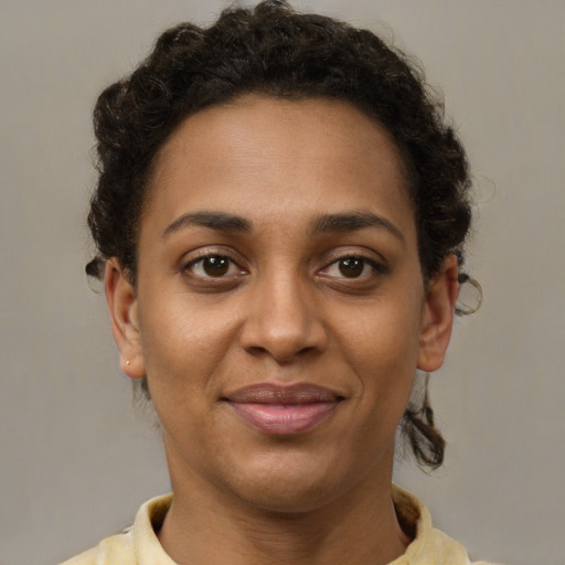 Joyful black young-adult female with short  brown hair and brown eyes